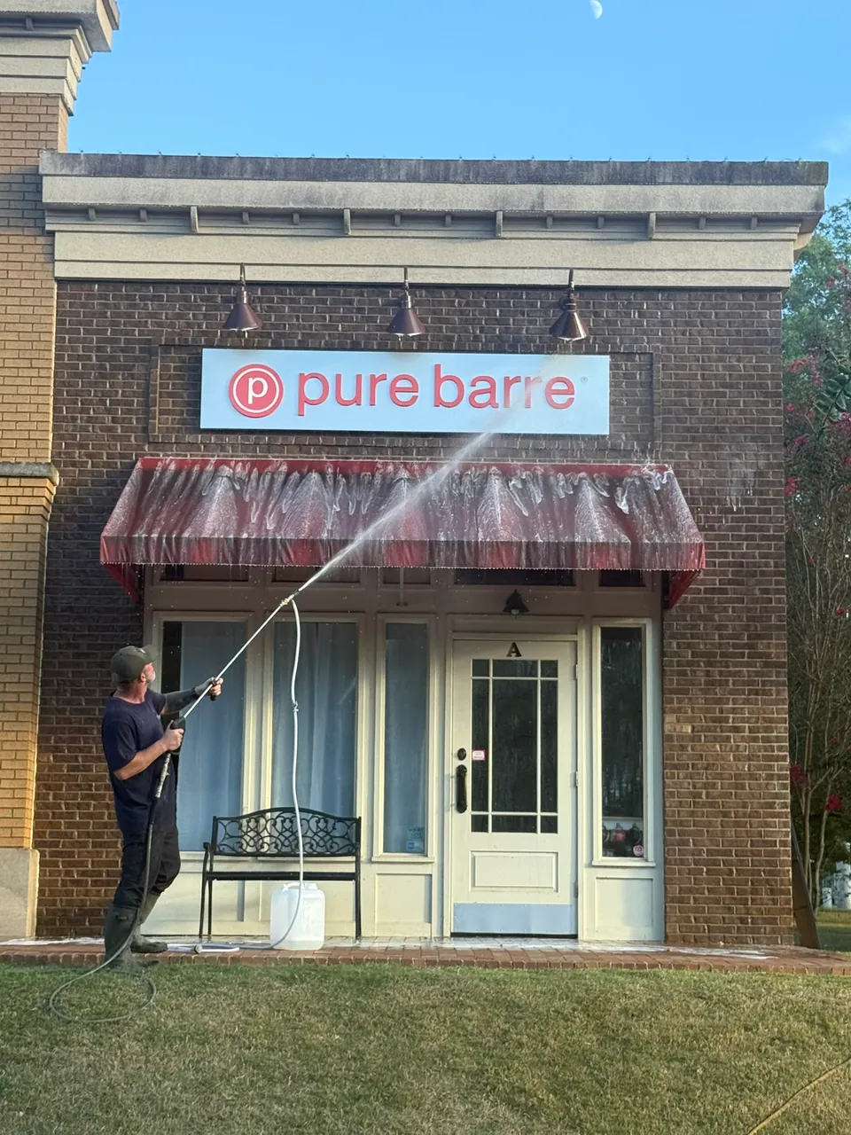 Operator cleaning the exterior above a retail storefront